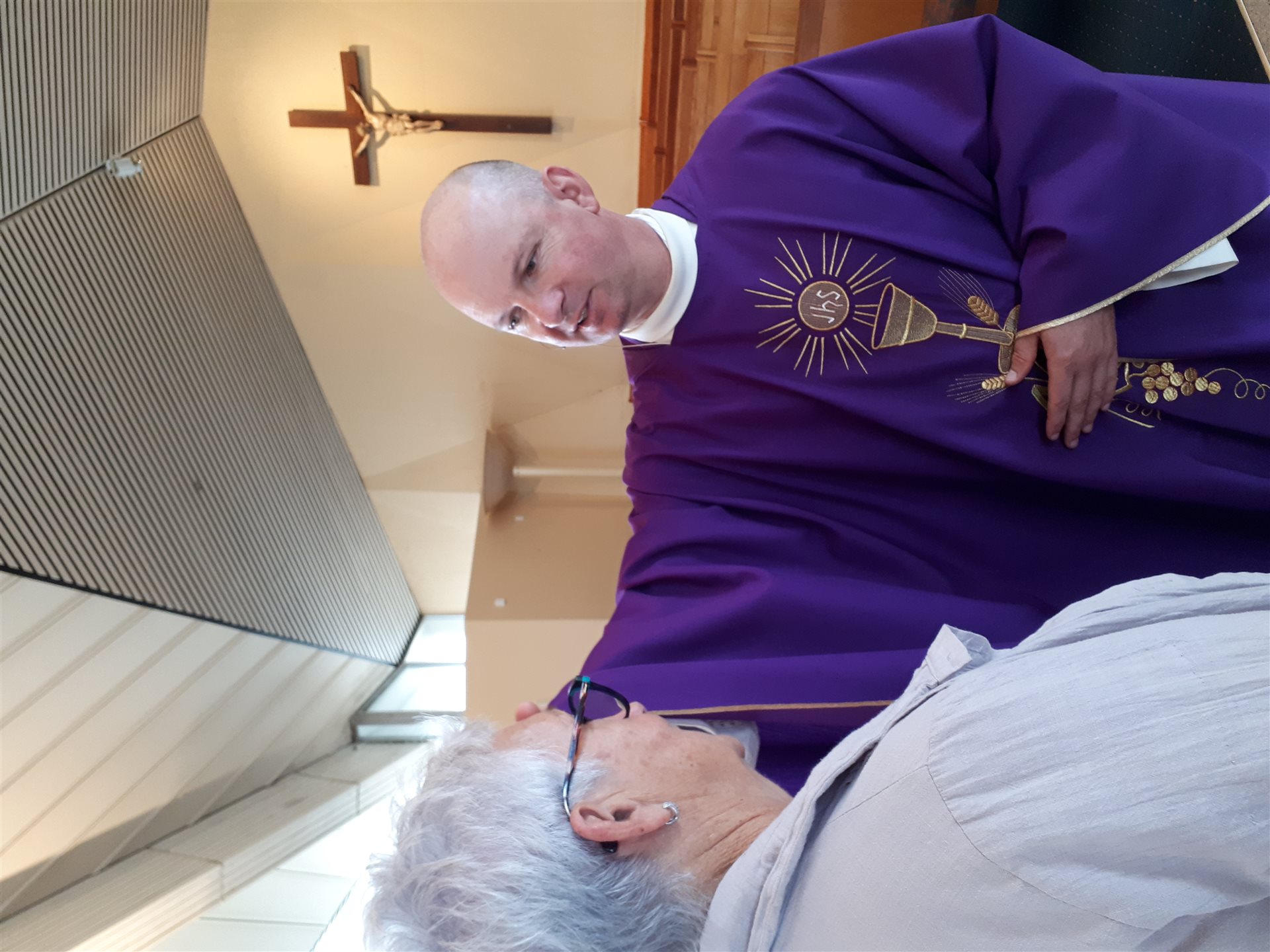 A priest anointing a parishioner during Mass